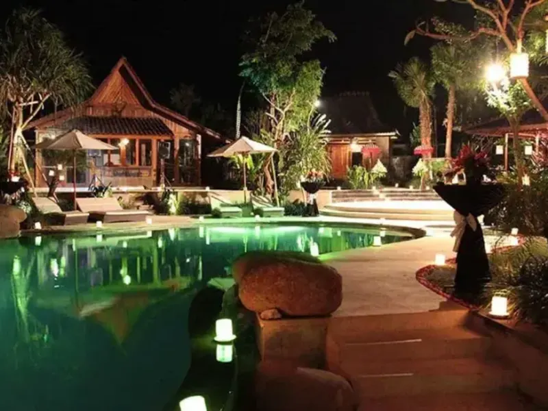 Timber pavilion lit at night in Bali